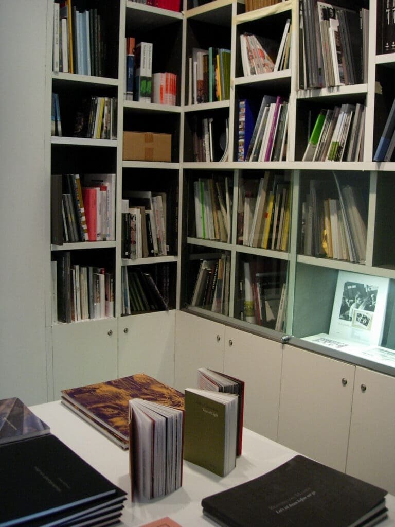 Librairie remplie de livres et catalogues exposés sur une table.