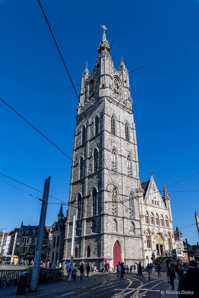 Beffroi de Gand sous un ciel bleu avec tramway.