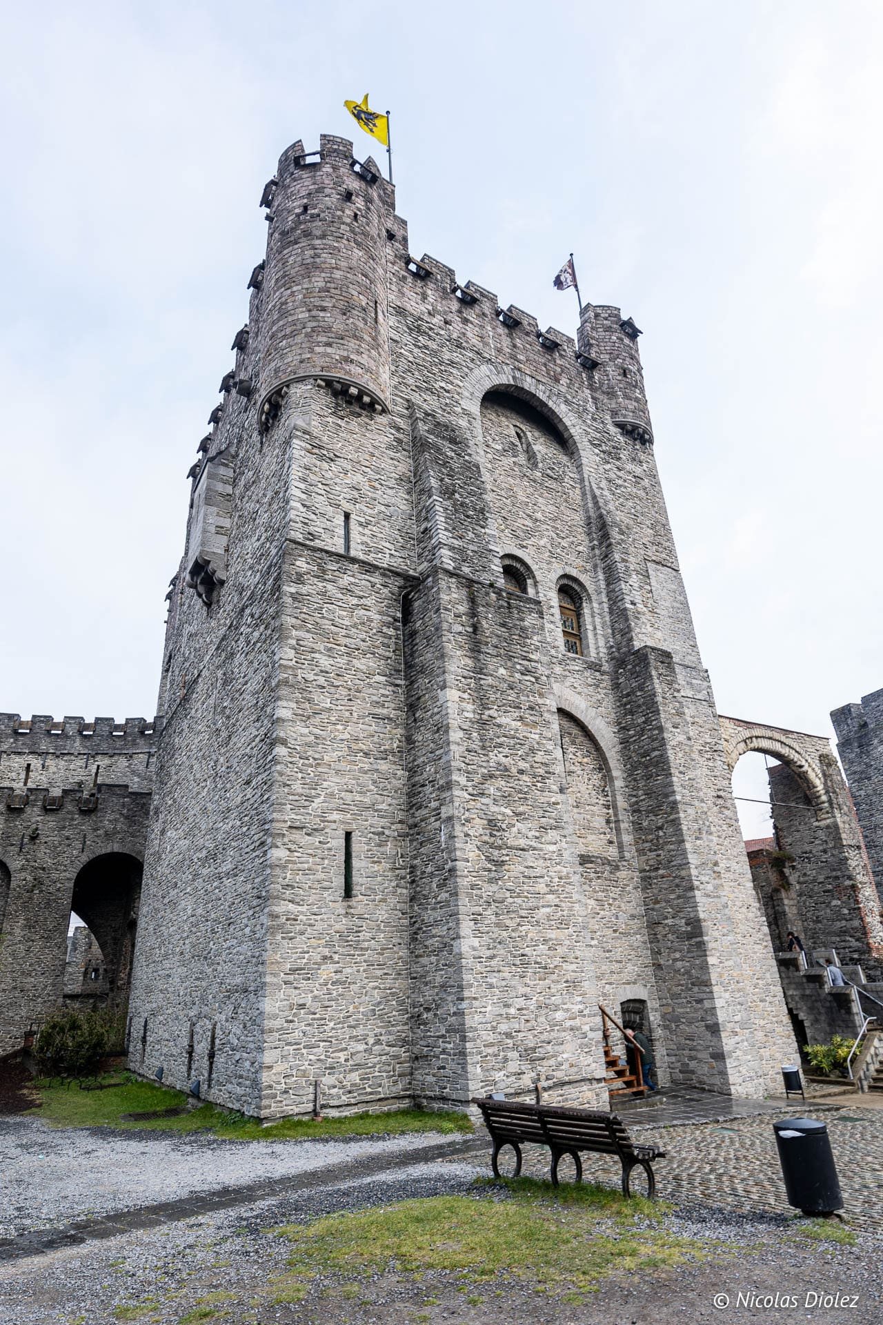 Château des Comtes de Gand en pierre, avec drapeaux flottant sur les tours.