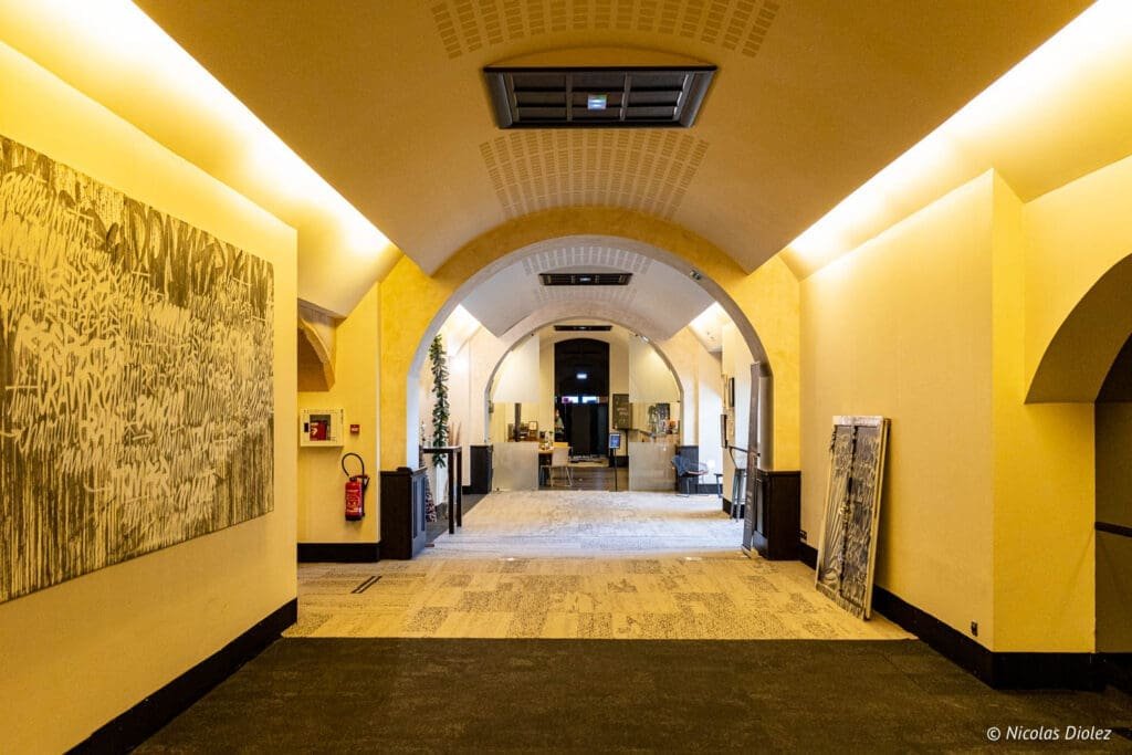 Hall de l'Hôtel MGallery La Citadelle Metz avec arches et œuvres d'art.