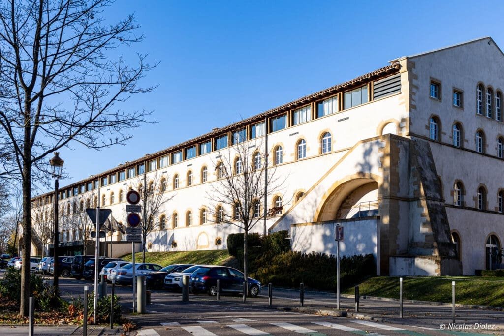 Hôtel MGallery La Citadelle Metz extérieur avec parking et ciel bleu.