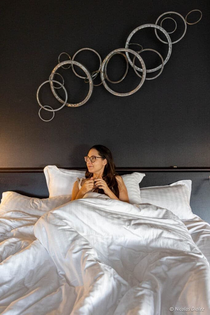 Femme au lit à l'Hôtel MGallery La Citadelle Metz.