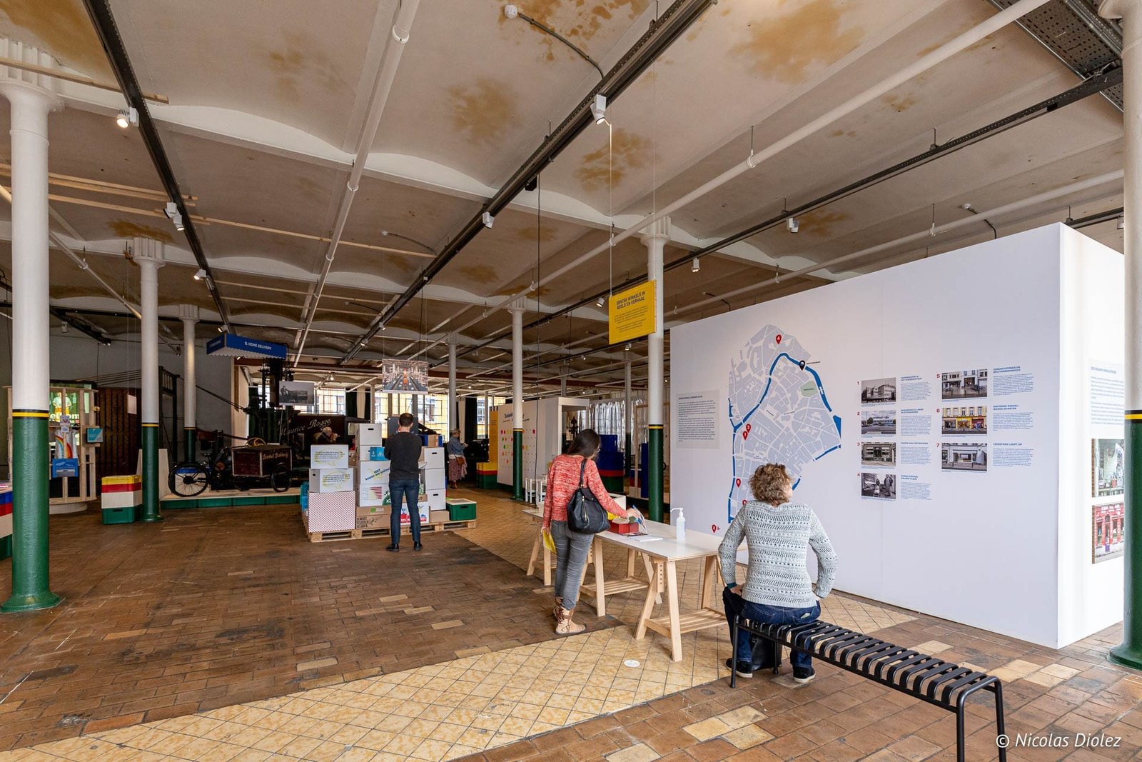 Intérieur du Musée de l'Industrie de Gand avec visiteurs et carte de la ville.