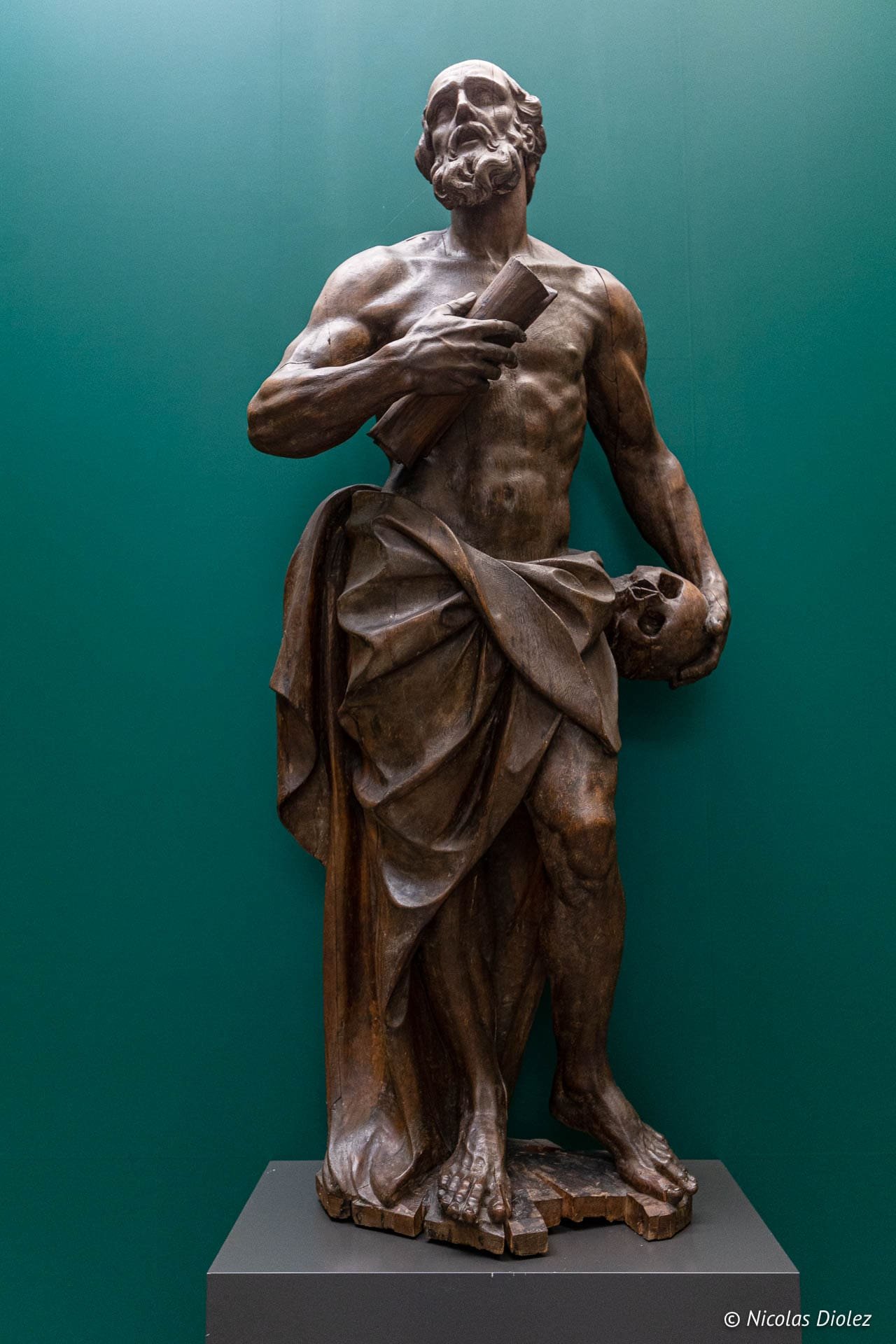 Sculpture en bois d'un saint barbu tenant un livre et un crâne au Musée des Beaux-Arts de Gand.