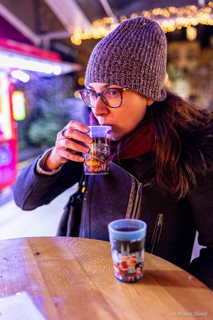 Femme buvant une boisson chaude au marché de Noël de Metz.