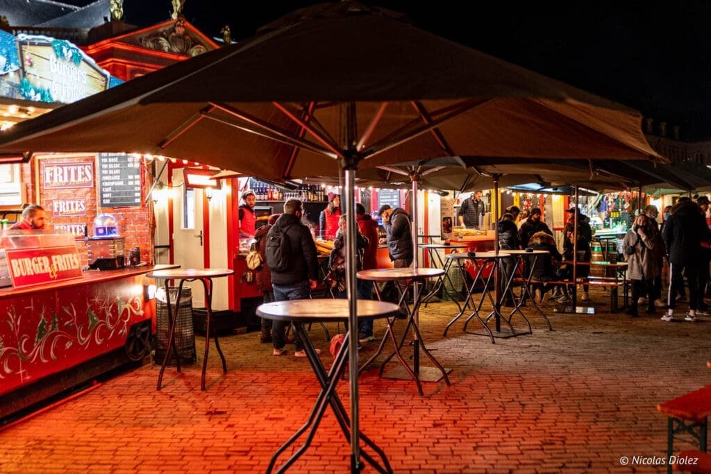 Village de Noël Metz ambiance nocturne avec stands de frites et de burgers.