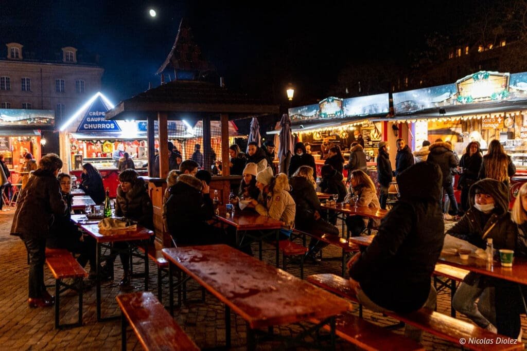 Village de Noël Metz la nuit avec stands de crêpes et churros.
