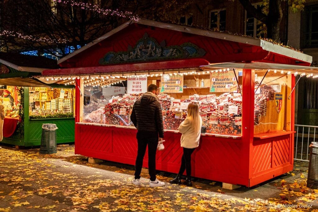 Couple acheteurs devant un stand de saucissons au Village de Noël de Metz.