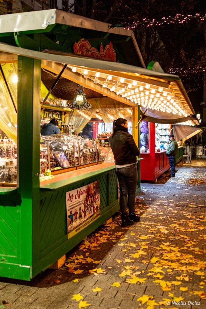 Chalet du Marché de Noël de Metz avec lumières et feuilles d'automne.