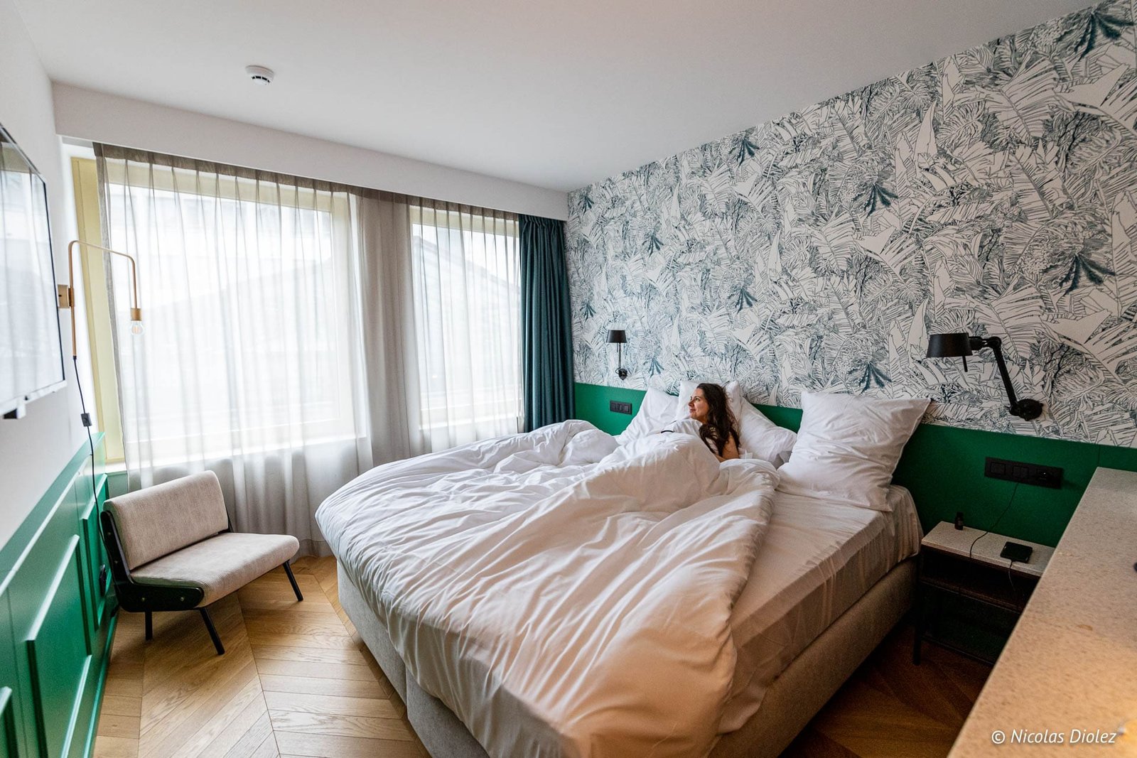 Femme se réveillant dans une chambre d'hôtel Yalo à Gand.