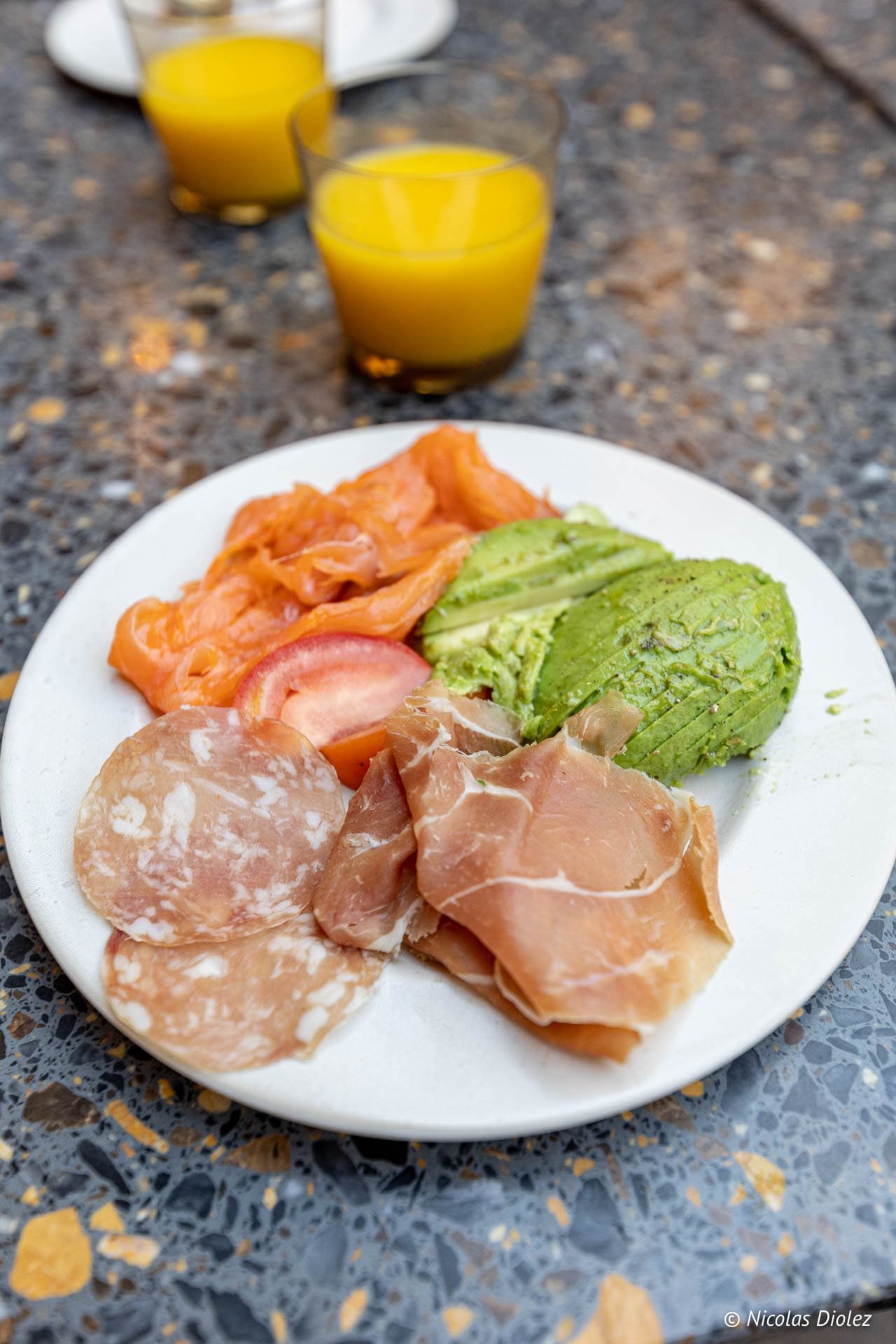 Assiette de petit-déjeuner avec saumon fumé, avocat, charcuterie et jus d'orange à Gand.