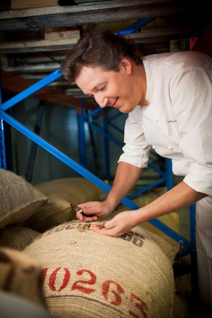 Pierre Marcolini vérifie des fèves de cacao dans un entrepôt.