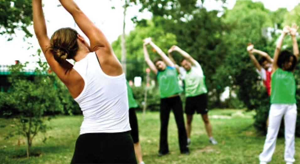 Etirements_Andros_Matin_©Urban_Challenge Groupe faisant des étirements en plein air, exercice matin Urban Challenge.