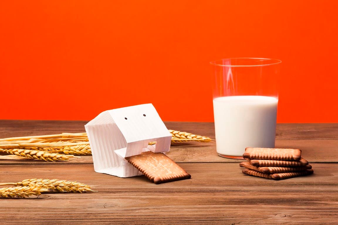 Matali-Crasset-LU-Packshot ©-Pascal-montary Boîte en carton créative avec biscuit sortant, lait, et épis de blé.