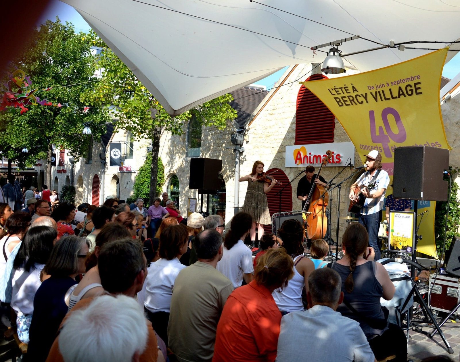 Concert de musique en plein air à Bercy Village avec musiciens et public.