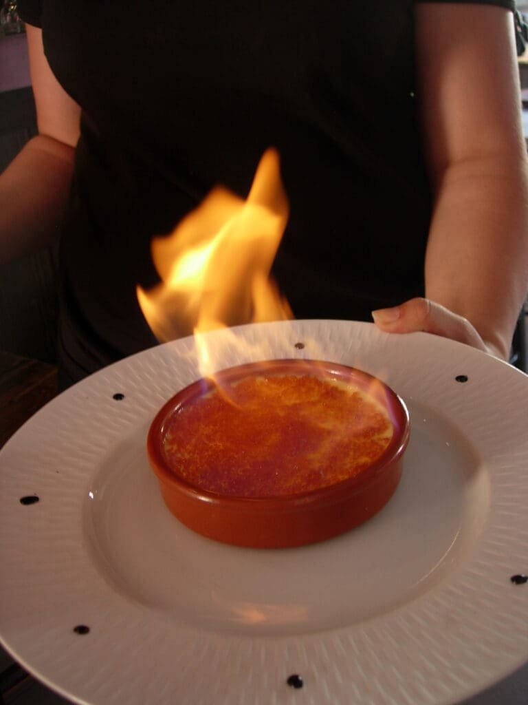 Flamage d'une crème brûlée par un serveur au restaurant Cook & Lab.