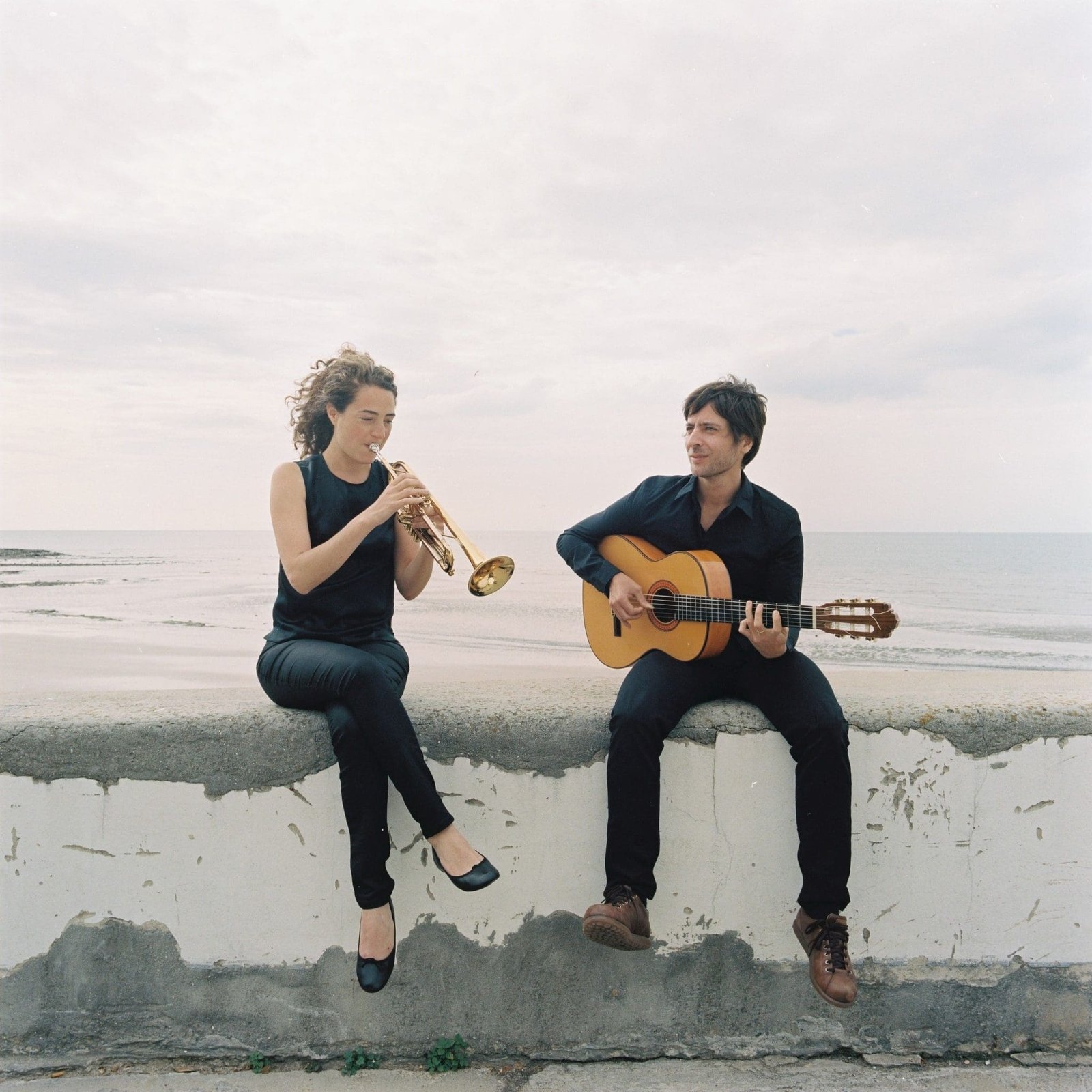 Airelle Nelson, trumpet player and guitarist, playing by the sea.