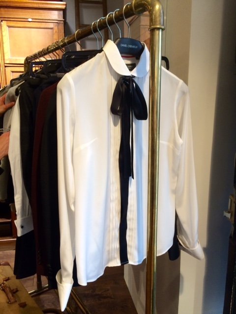 Chemise blanche femme Daniel Crémieux avec nœud noir sur portant laiton.