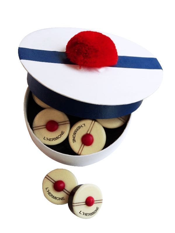 L'Hermione chocolates shaped like red pompons in a sailor cap style box.