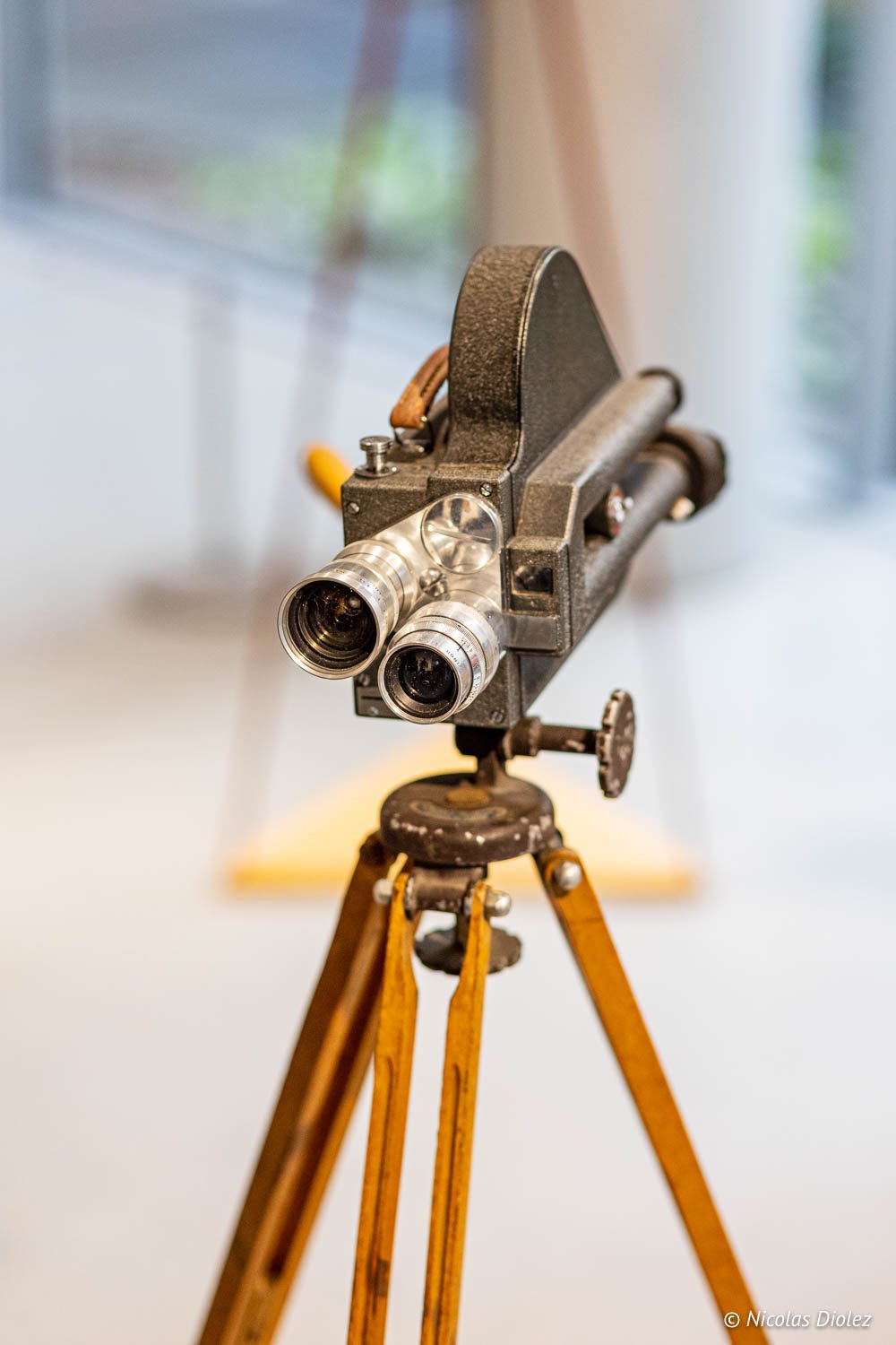 Caméra de cinéma ancienne sur trépied bois exposition Fondation Seydoux-Pathé.