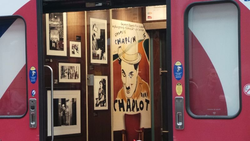 cinéma 2 Exposition Chaplin avec affiches et photos dans une entrée de wagon rouge.