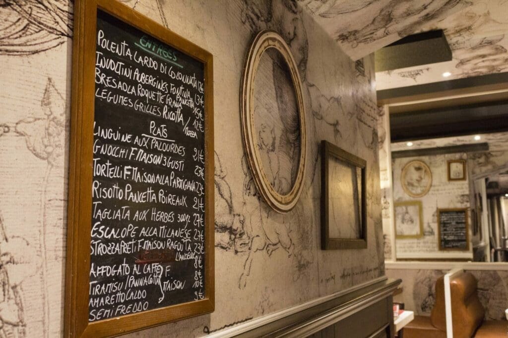 Ardoise de plats italiens et desserts dans restaurant avec décorations dessins.