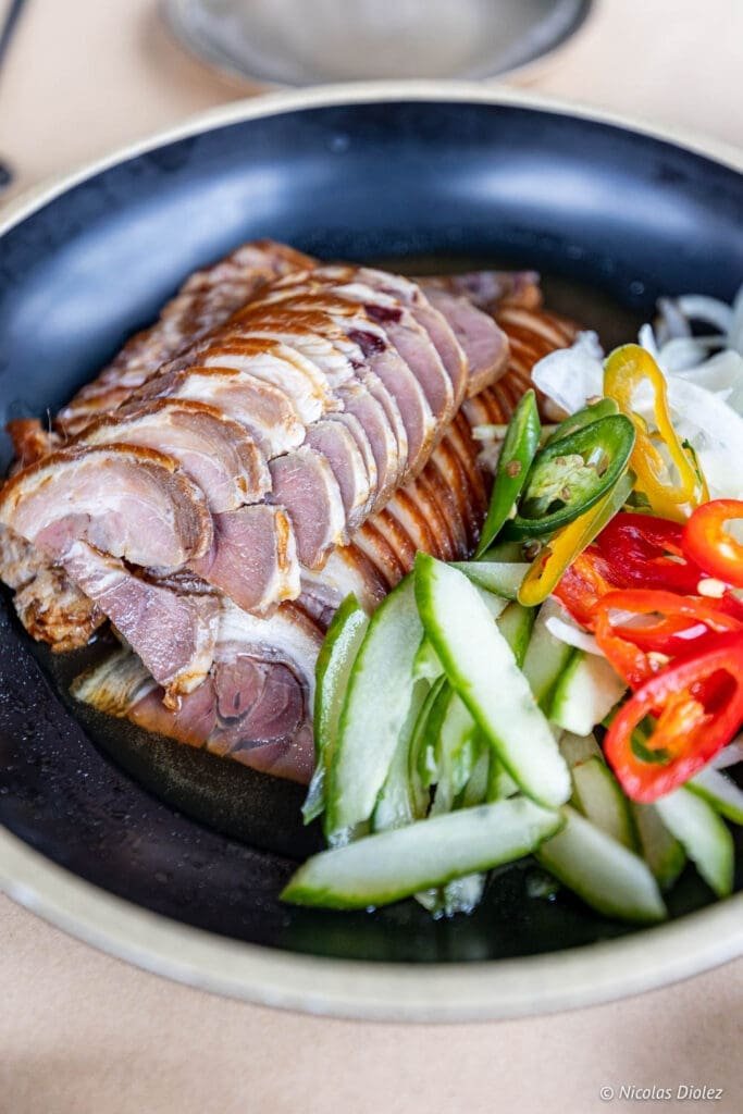 Jokbal (porc braisé) tranché servi avec des concombres et piments au restaurant Bekseju Village.