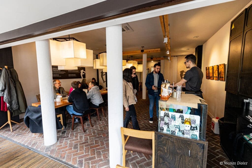 Intérieur du restaurant coréen Bekseju Village avec clients à table et au comptoir.