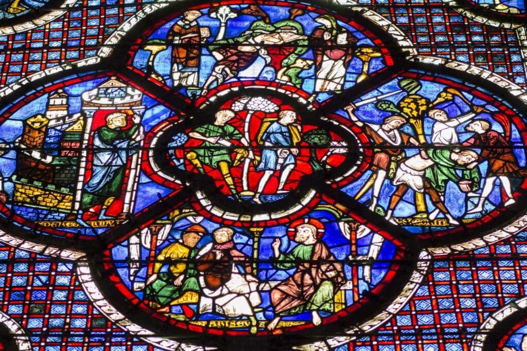 Vitrail gothique de la cathédrale de Chartres illustrant des scènes bibliques et historiques.