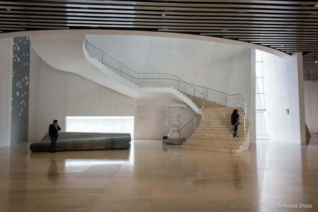 Intérieur moderne du Musée International du Baroque Puebla avec escalier courbé.