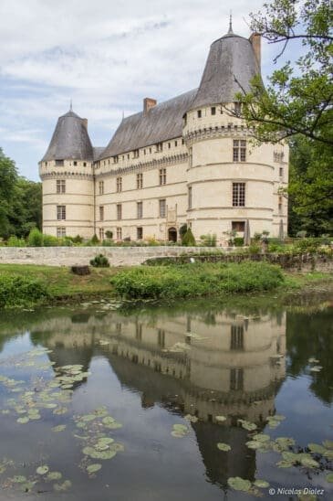 Château de L’Islette reflected in the water with water lilies.