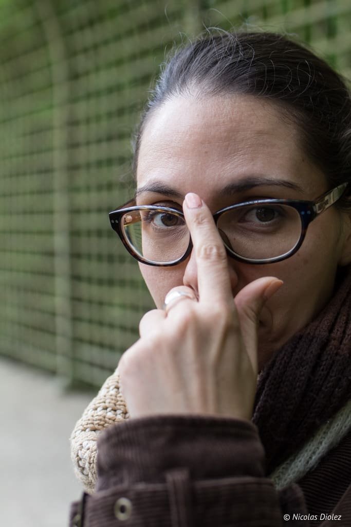 Portrait femme ajustant ses lunettes à Versailles.