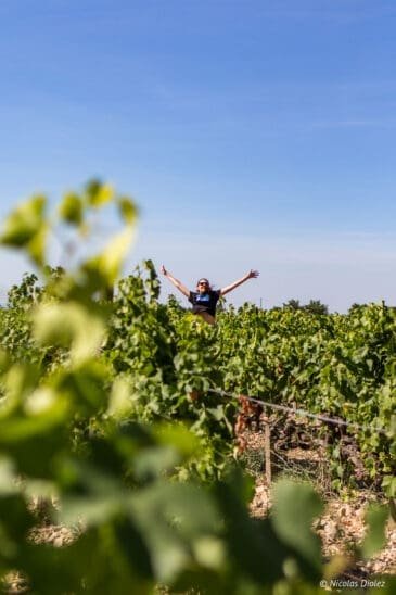Happy person with arms open in the middle of a Vacqueyras vineyard.