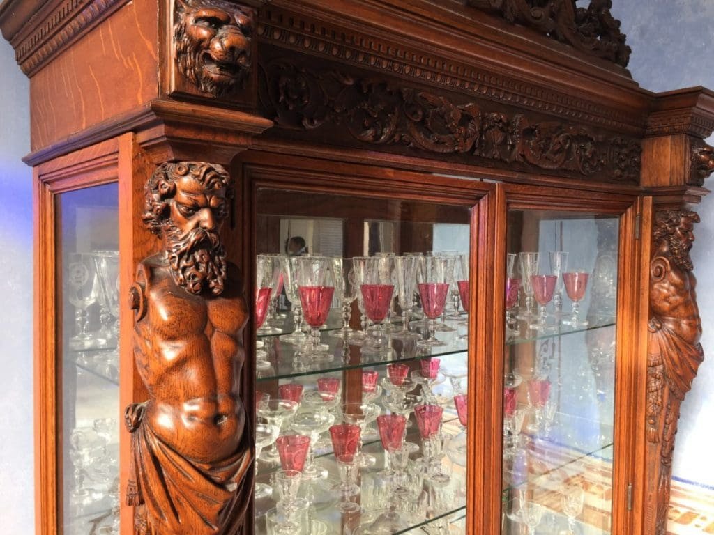 Casa Marques de Arcos. DR Valérie Collet 2018 Vitrine sculptée en bois avec buste d'homme barbu, verres à pied rouges et transparents.