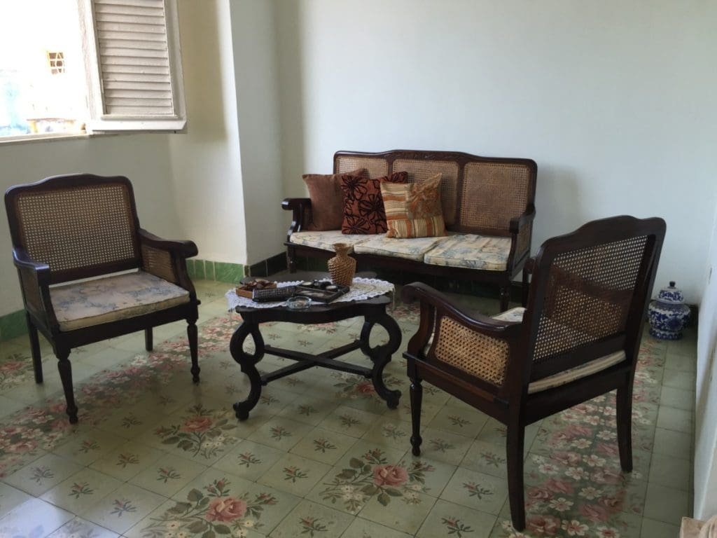 Casa colonial Habana DR Valérie Collet 2018 Salon colonial de la Maison coloniale Habana avec meubles en rotin et sol à motifs floraux.