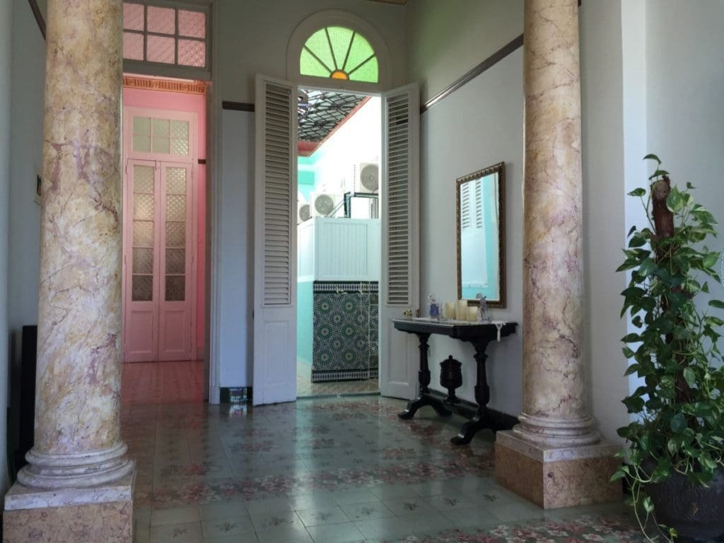 Casa colonial Habana DR Valérie Collet 2018 Intérieur Maison coloniale Habana avec colonnes marbrées, sol fleuri et portes ouvertes.