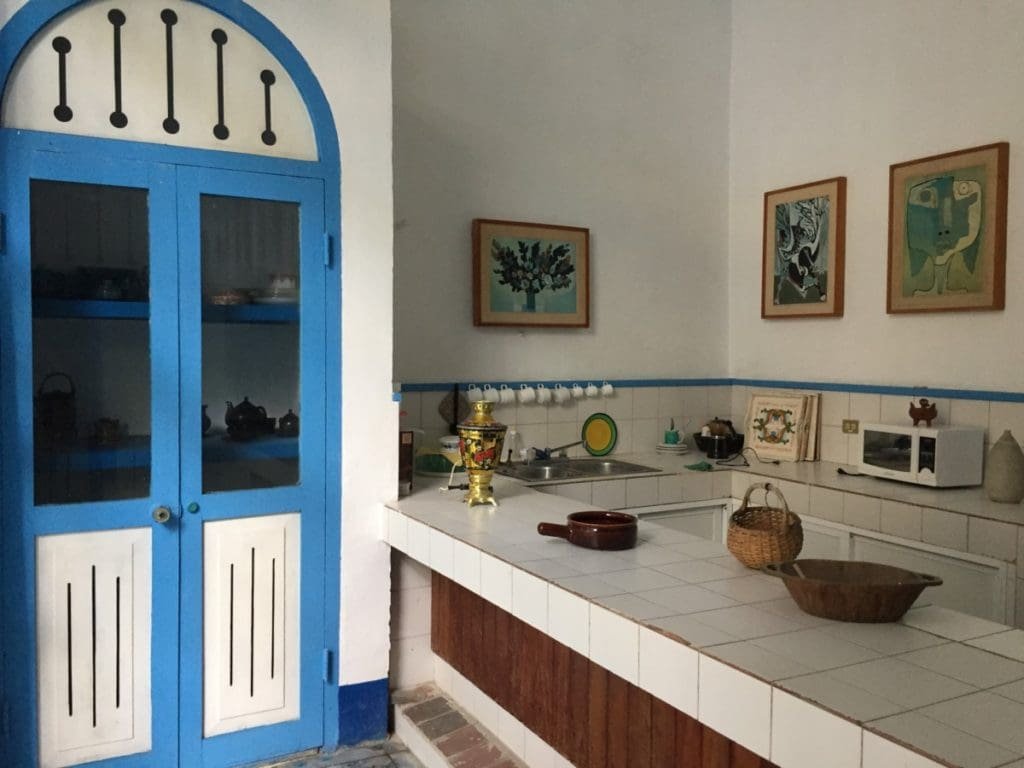 Casa de Guyasamin. DR Valérie Collet 2018 Cuisine de la Maison d’Oswaldo Guyasamin à La Havane avec porte bleue et tableaux.