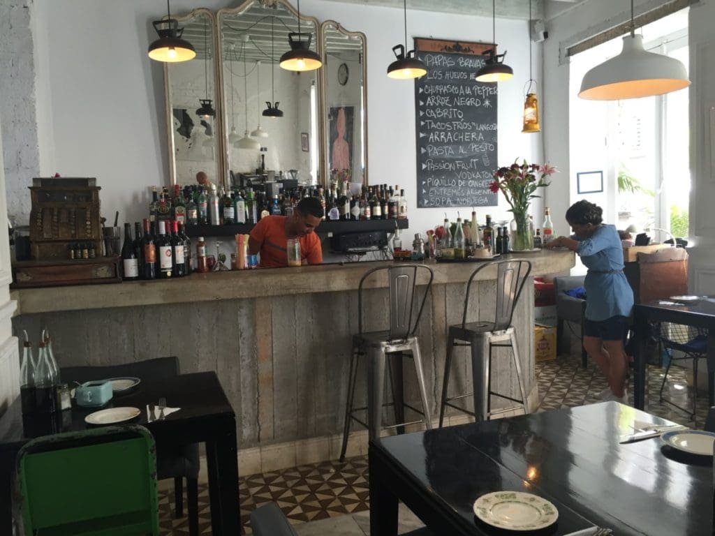 El del Frente DR Valérie Collet 2018 Intérieur restaurant El del Frente, barman préparant une boisson devant le tableau des menus.