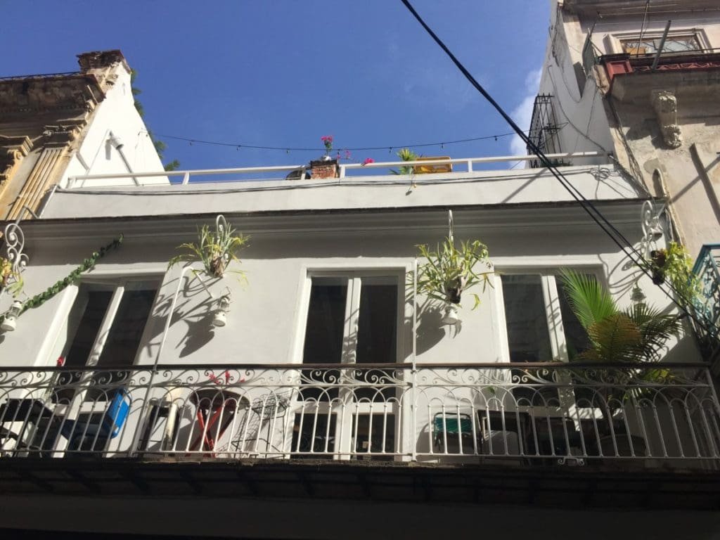 El del Frente DR Valérie Collet 2018 Façade blanche avec balcon en fer forgé et plantes suspendues, Restaurant El del Frente, La Havane.