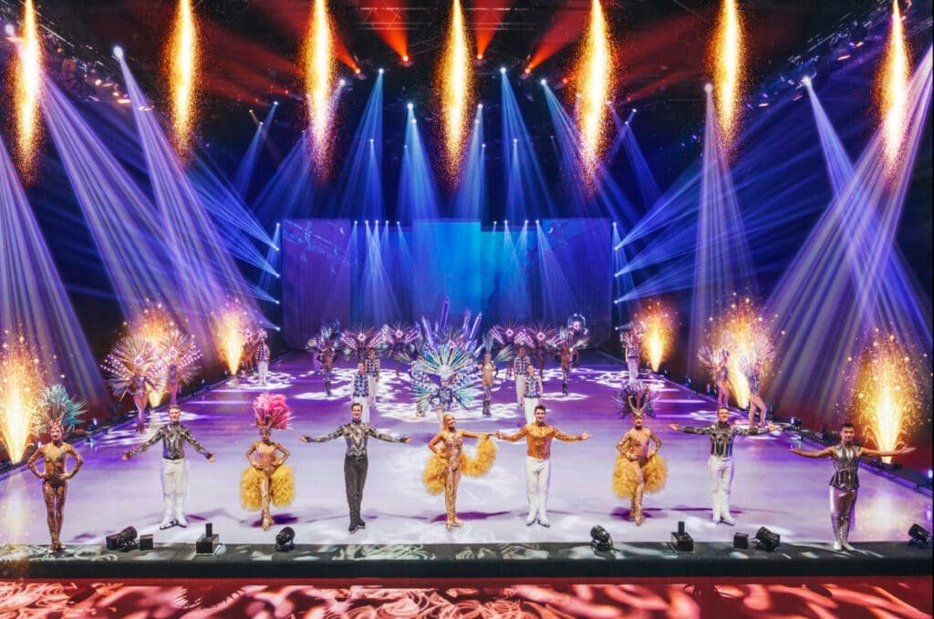 Figure skating show with dancers and fireworks on stage.