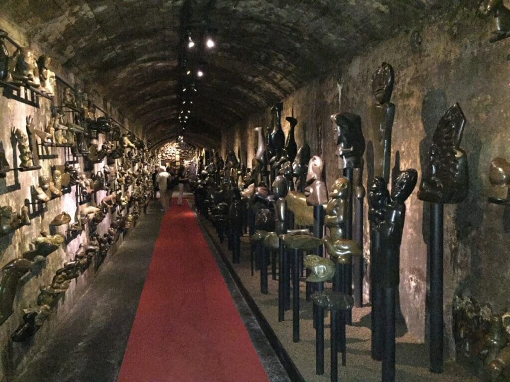 Alliage Underground Museum, sculptures dans un long couloir voûté avec tapis rouge.