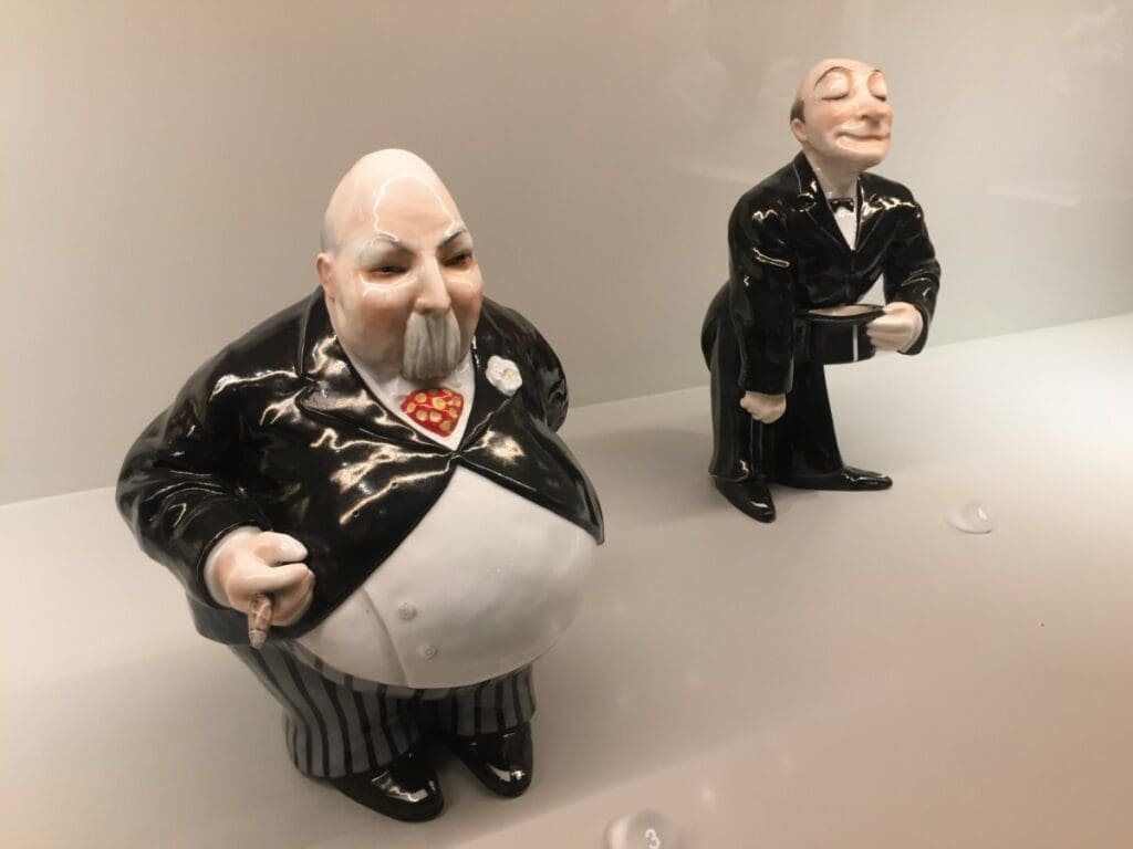 Musée Vista Alegre 6 DR Valérie Collet 2019 Figurines de porcelaine Vista Alegre: homme obèse et valet tenant un chapeau.