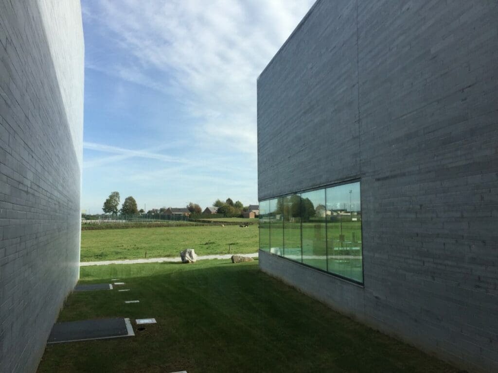 Musverre -DR Valérie Collet 2019 Vue extérieure du Musverre à Sars-Poteries entre deux murs modernes et un champ.