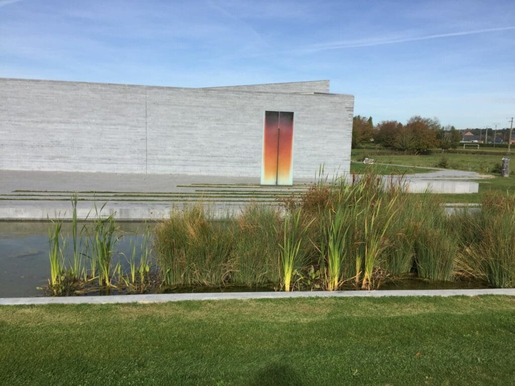 Musée Vista Alegre 1 DR Valérie Collet 2019 Façade Musverre de Sars-Poteries avec porte dégradée, étang et végétation.