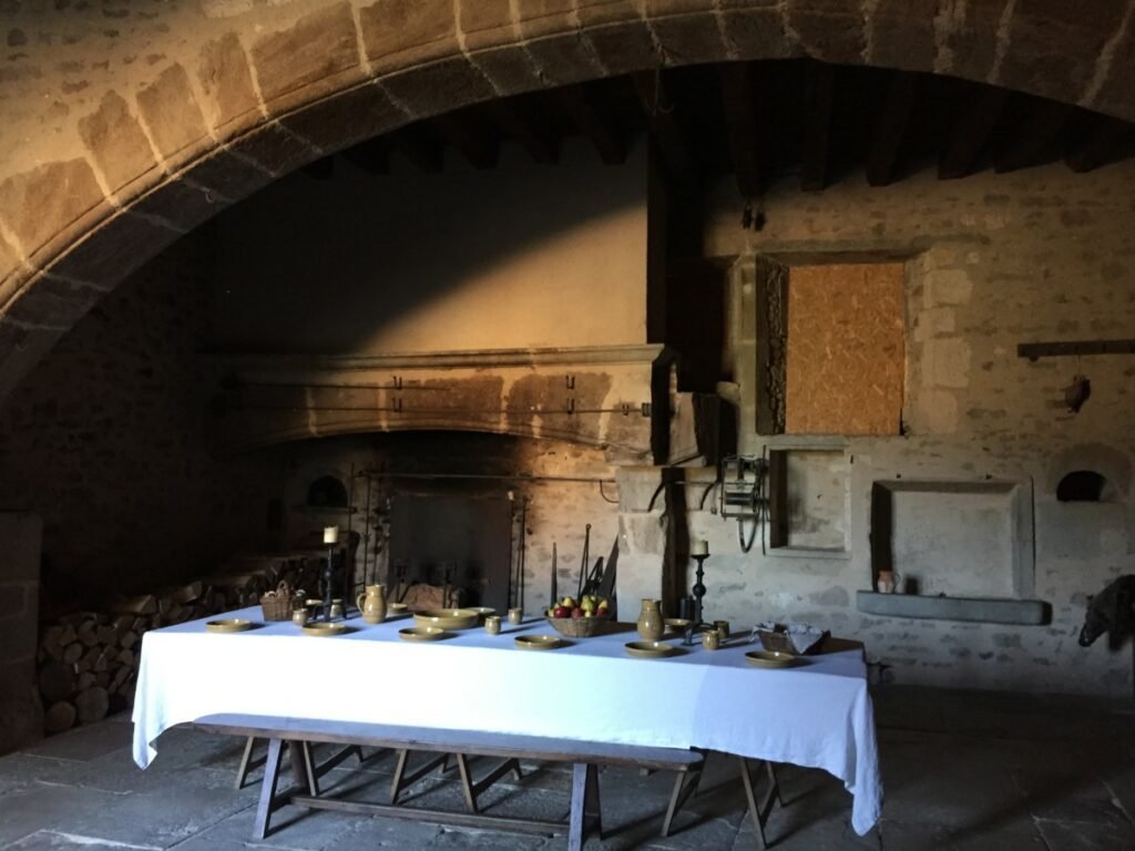 Château de Pierreclos - DR Valérie Collet 2019 Ancienne cuisine en pierre avec table dressée pour un repas historique.