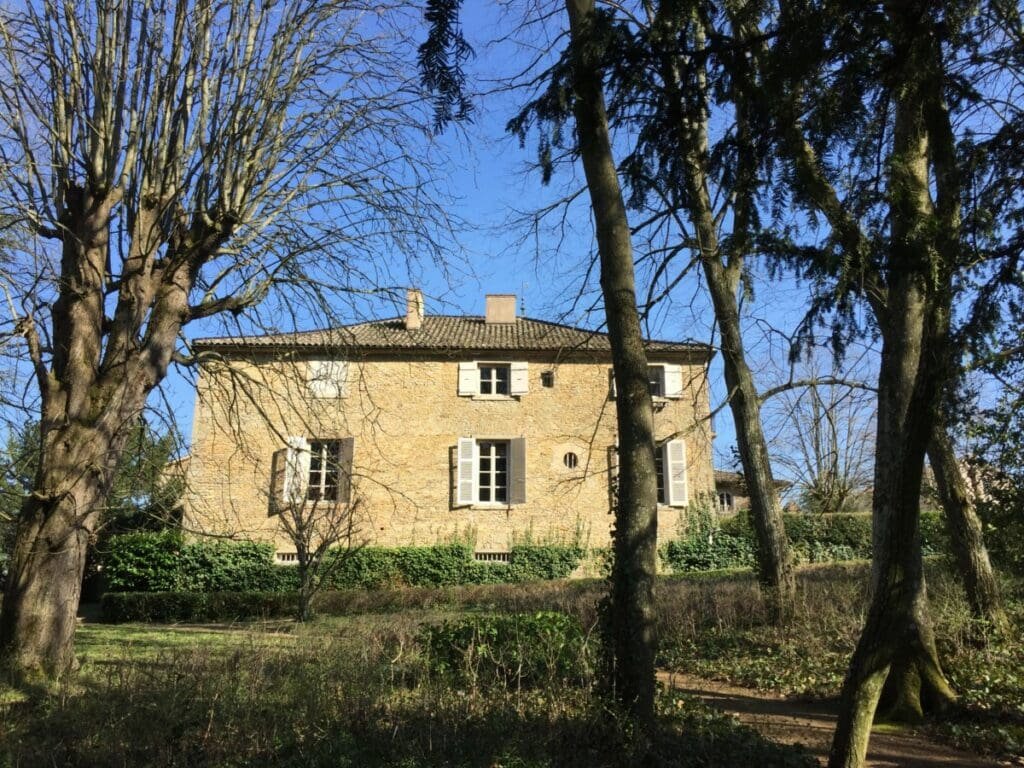 Maison familiale de Lamartine à Milly vue à travers des arbres dénudés.