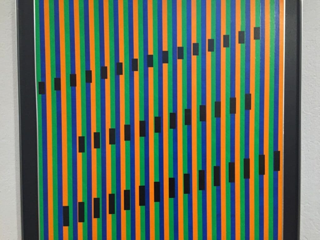 Œuvre d'art optique rayures orange, vertes, bleues avec formes noires au Musée des Ursulines.