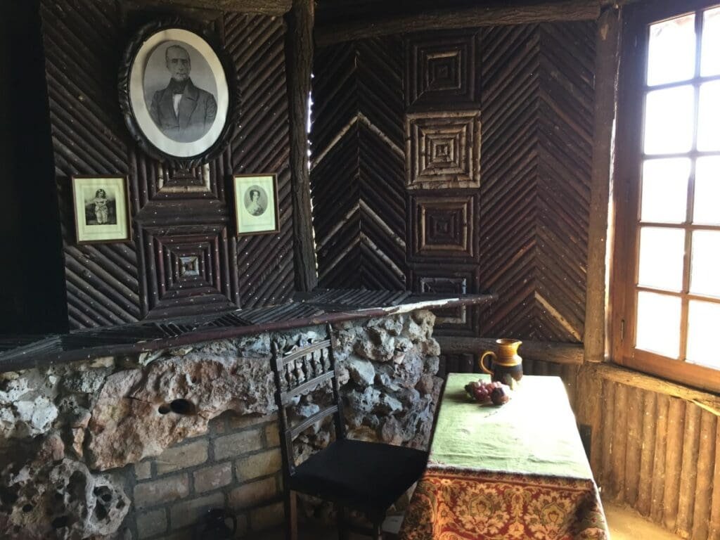 Intérieur rustique Pavillon La Solitude Lamartine avec portraits sur mur en bois.