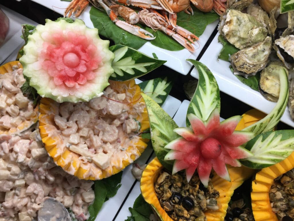 Art culinaire cubain : salades crémeuses et sculptures de fruits exotiques.