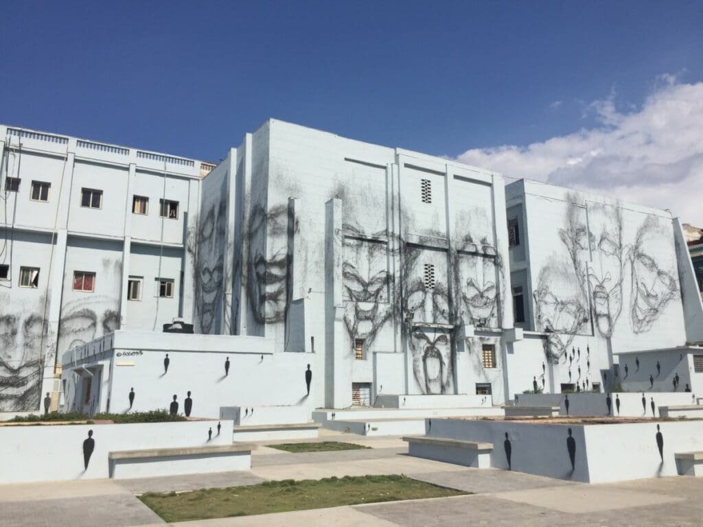 Art urbain Biennale de la Havane: fresques murales et silhouettes noires sur bâtiment.